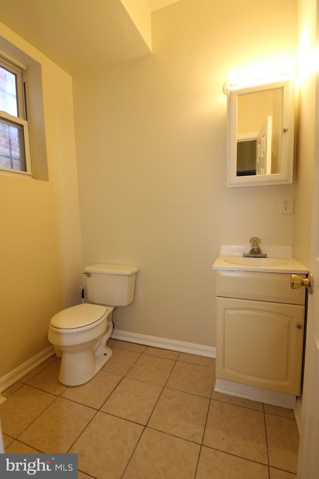 bathroom with toilet, vanity, and tile patterned flooring