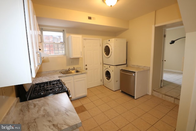 laundry area with sink, stacked washer / dryer, and light tile patterned flooring