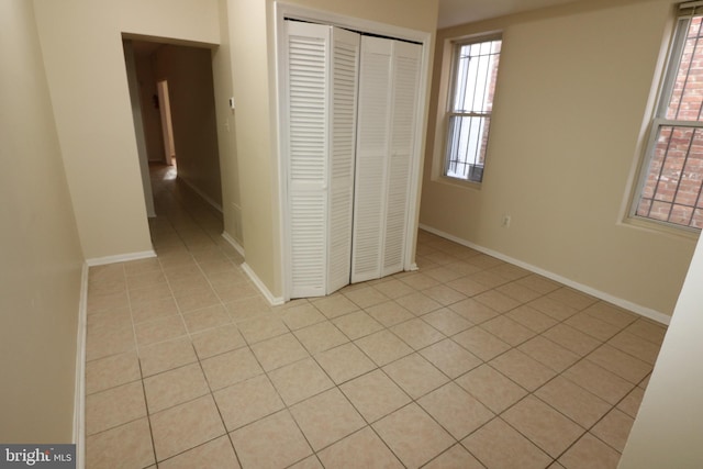 unfurnished bedroom featuring a closet and light tile patterned flooring