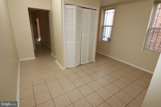 403 O St NW, Washington, DC 20001 - unfurnished bedroom featuring light tile patterned flooring, a closet, and baseboards