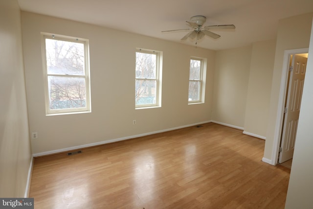 unfurnished room featuring light hardwood / wood-style flooring, ceiling fan, and a wealth of natural light