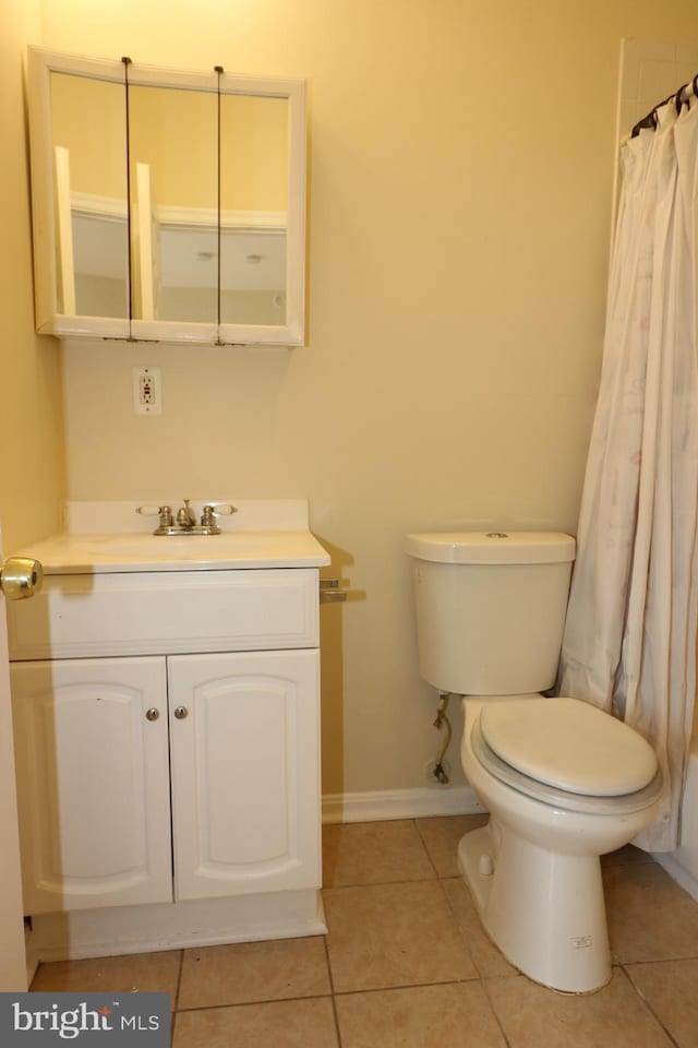 bathroom with vanity, toilet, walk in shower, and tile patterned flooring