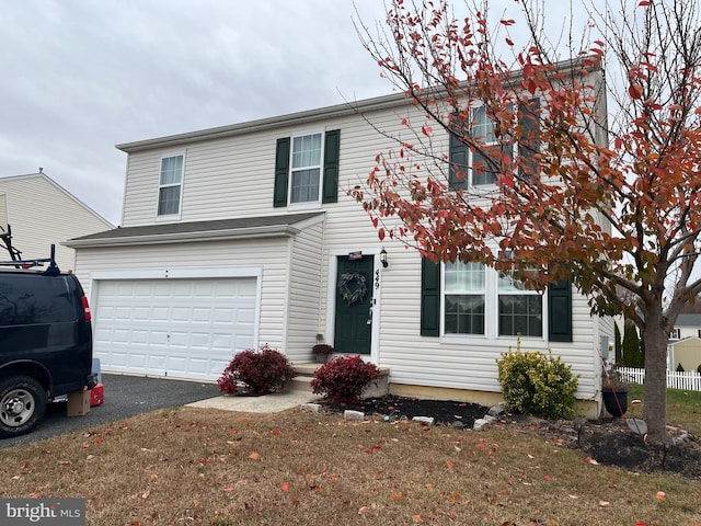 view of front of property featuring a garage and a front lawn