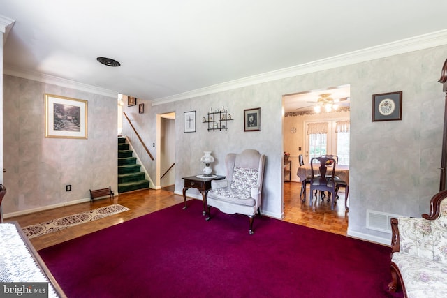 living area featuring crown molding and ceiling fan