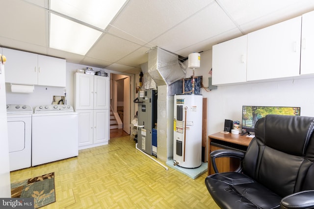 basement featuring electric water heater, a paneled ceiling, separate washer and dryer, and light parquet floors