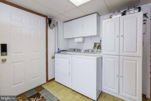 washroom with separate washer and dryer, light parquet flooring, and cabinets