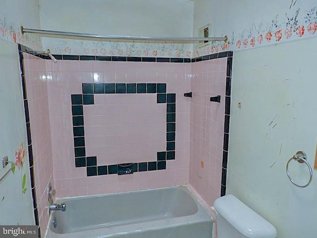 bathroom with toilet and tiled shower / bath combo