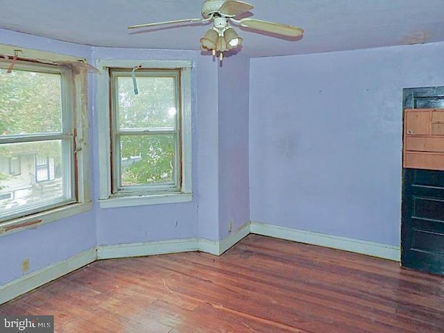 unfurnished room with a healthy amount of sunlight, hardwood / wood-style flooring, and ceiling fan