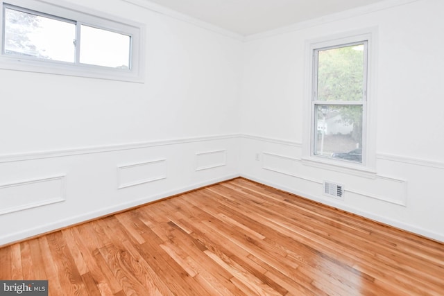 empty room featuring ornamental molding and light hardwood / wood-style floors