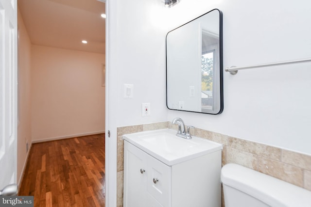 bathroom featuring vanity, toilet, tile walls, and hardwood / wood-style floors