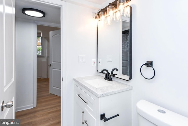 bathroom with vanity, toilet, and hardwood / wood-style flooring