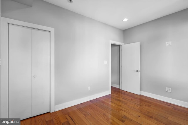 unfurnished bedroom featuring hardwood / wood-style floors and a closet