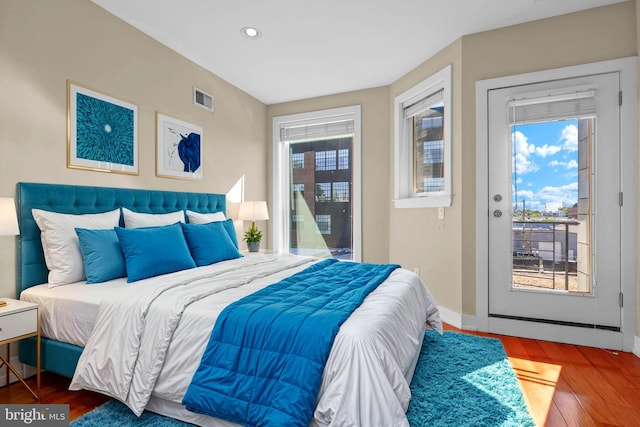 bedroom with hardwood / wood-style floors and multiple windows