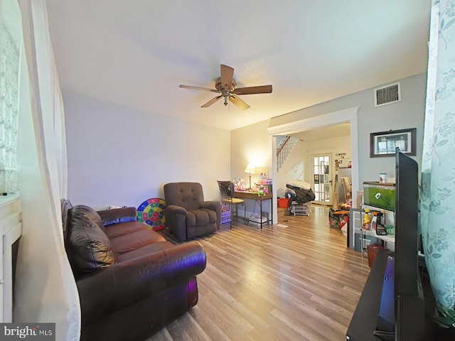 living room featuring ceiling fan and light hardwood / wood-style floors