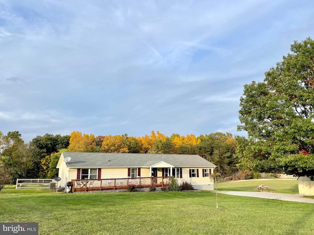 ranch-style home with a front yard and a deck