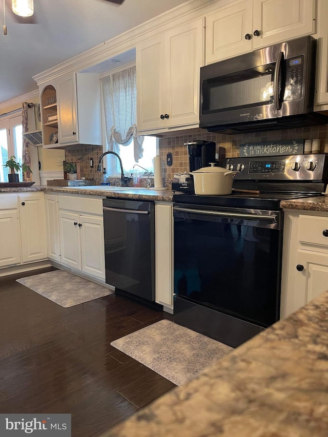 kitchen with dark wood-type flooring, tasteful backsplash, appliances with stainless steel finishes, and white cabinets