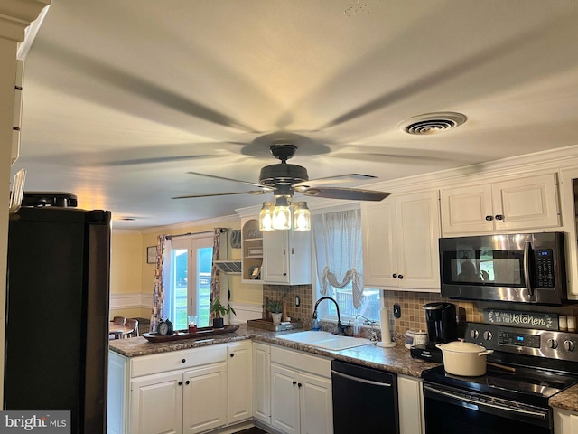 kitchen featuring decorative backsplash, white cabinets, dark stone countertops, sink, and stainless steel appliances