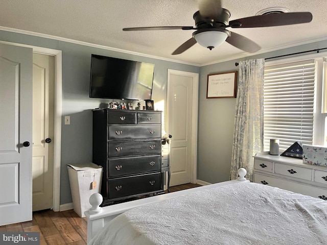 bedroom featuring dark hardwood / wood-style flooring, ornamental molding, a textured ceiling, and ceiling fan