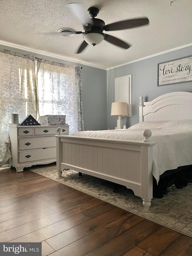 bedroom with crown molding, a textured ceiling, dark wood-type flooring, and ceiling fan