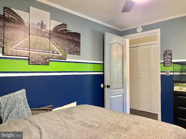 bedroom featuring carpet, ceiling fan, a textured ceiling, a closet, and crown molding