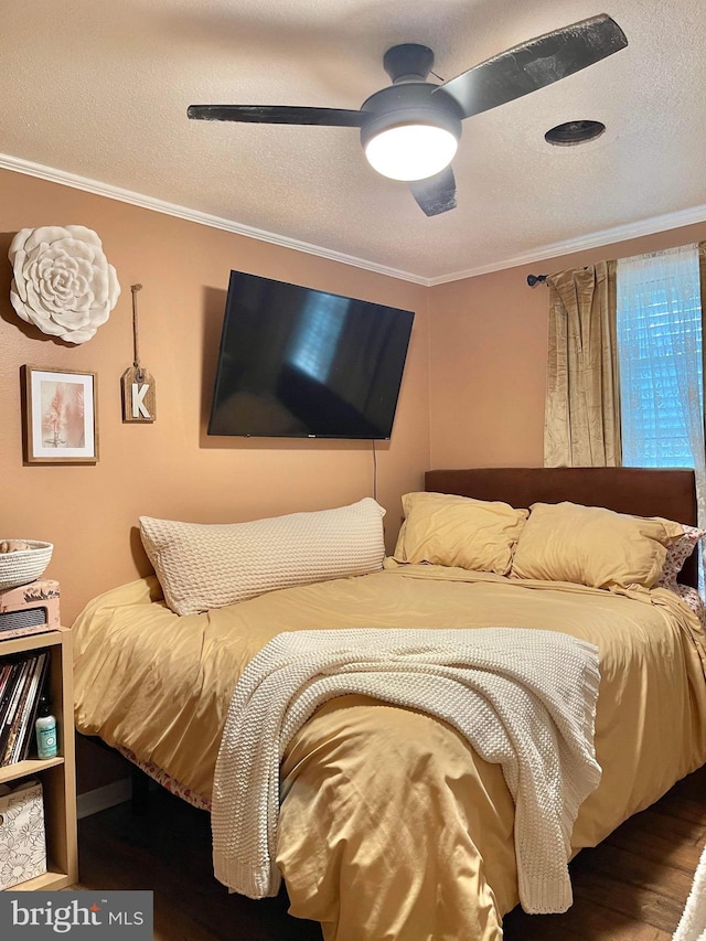 bedroom featuring ceiling fan, a textured ceiling, ornamental molding, and wood-type flooring