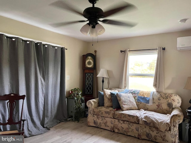 living room featuring ceiling fan, a wall mounted AC, and light wood-type flooring