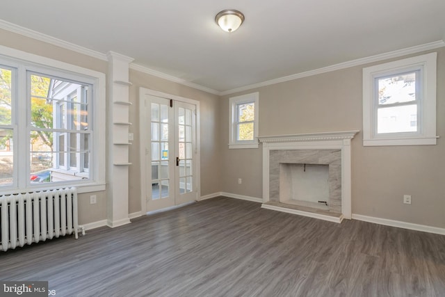 unfurnished living room with radiator, a healthy amount of sunlight, and dark wood-type flooring