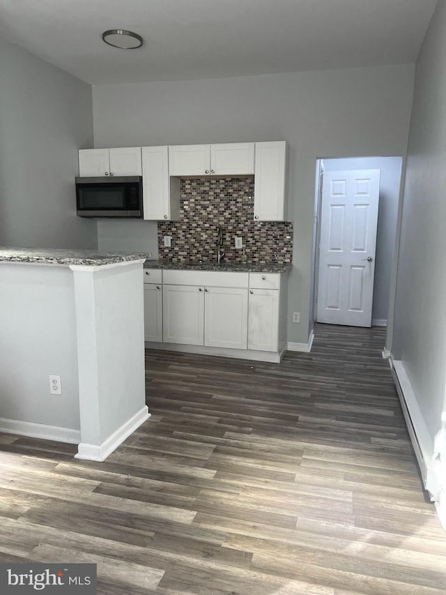 kitchen with white cabinets, sink, backsplash, and dark hardwood / wood-style floors