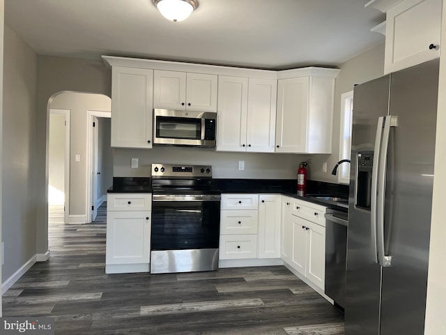 kitchen featuring dark hardwood / wood-style flooring, stainless steel appliances, and white cabinetry