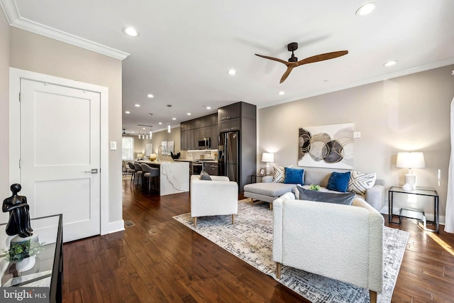 living room with dark hardwood / wood-style floors, ceiling fan, crown molding, and sink