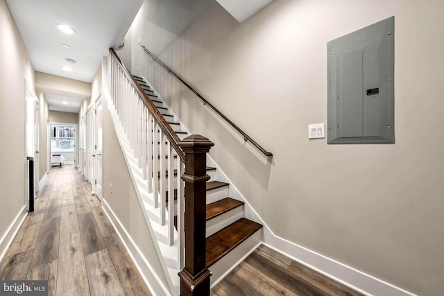 stairs with electric panel and wood-type flooring