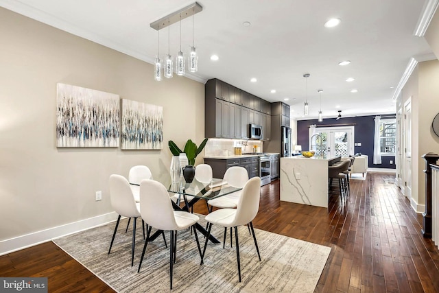 dining area with crown molding, dark hardwood / wood-style flooring, and sink