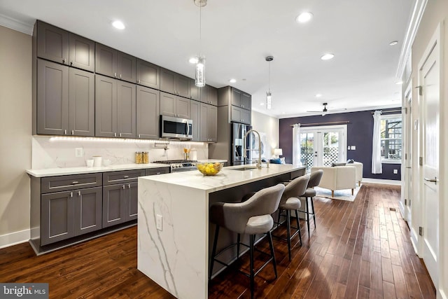 kitchen with sink, hanging light fixtures, dark hardwood / wood-style flooring, gray cabinets, and appliances with stainless steel finishes