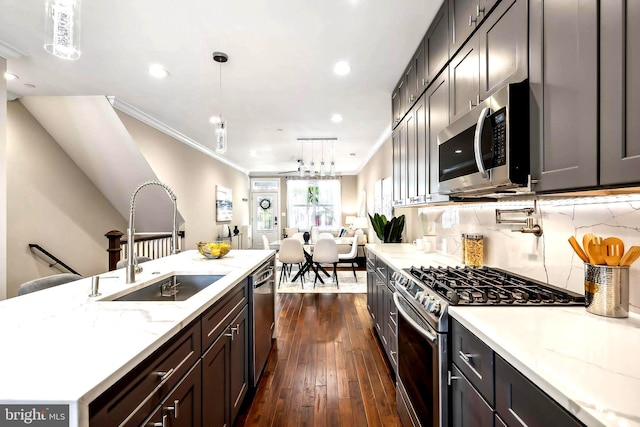 kitchen with dark hardwood / wood-style flooring, stainless steel appliances, crown molding, sink, and hanging light fixtures