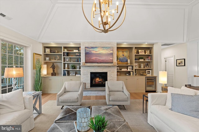 living room featuring light hardwood / wood-style floors, a stone fireplace, built in features, and wine cooler