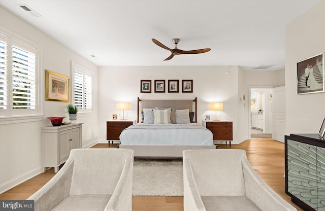 bedroom featuring connected bathroom, light hardwood / wood-style flooring, and ceiling fan