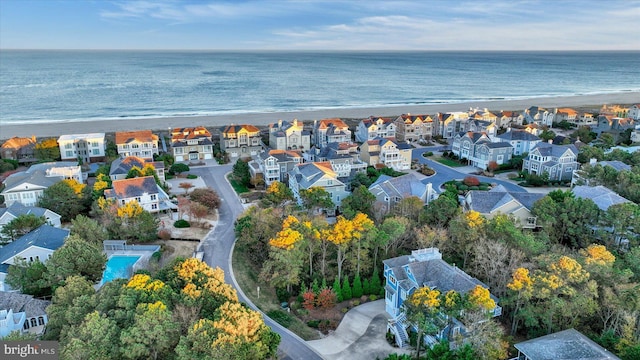 drone / aerial view featuring a water view and a beach view