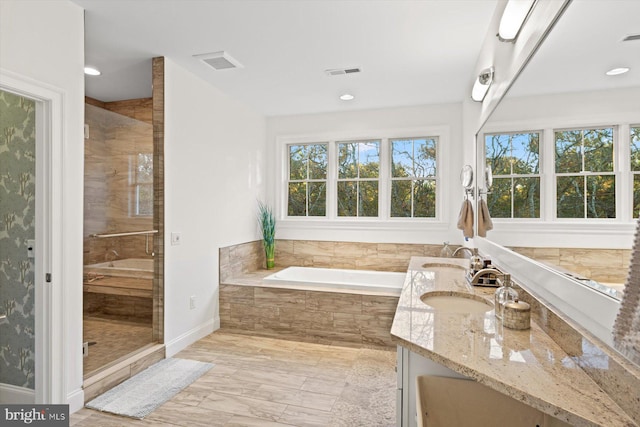 bathroom featuring plus walk in shower, hardwood / wood-style floors, and vanity