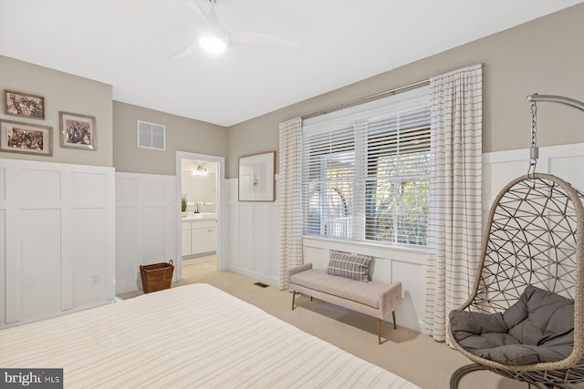 bedroom with light carpet, ceiling fan, and ensuite bathroom