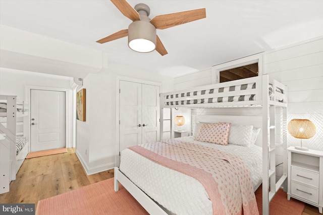 bedroom with a closet, light hardwood / wood-style floors, and ceiling fan