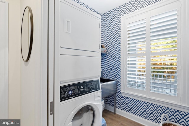 washroom featuring light wood-type flooring and stacked washer / dryer