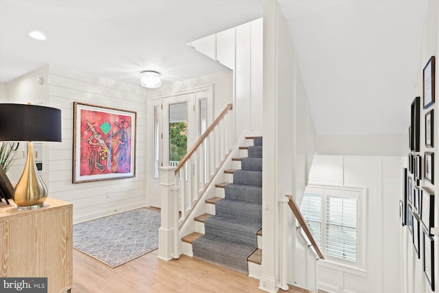 stairs with hardwood / wood-style flooring and a healthy amount of sunlight