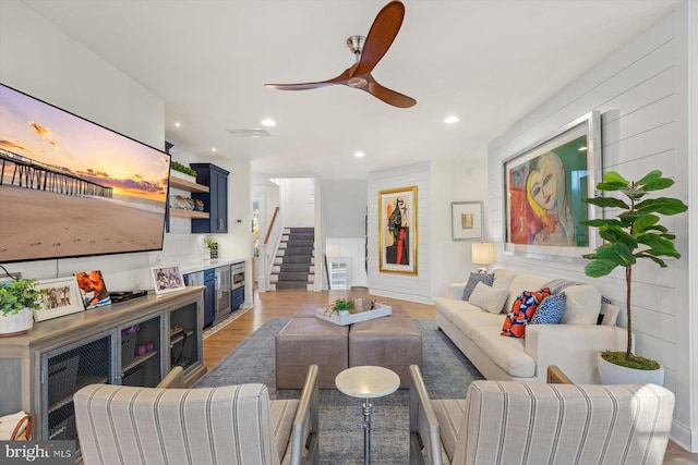 living room with light hardwood / wood-style flooring and ceiling fan