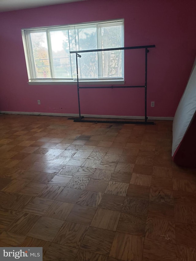 spare room featuring baseboards and a healthy amount of sunlight