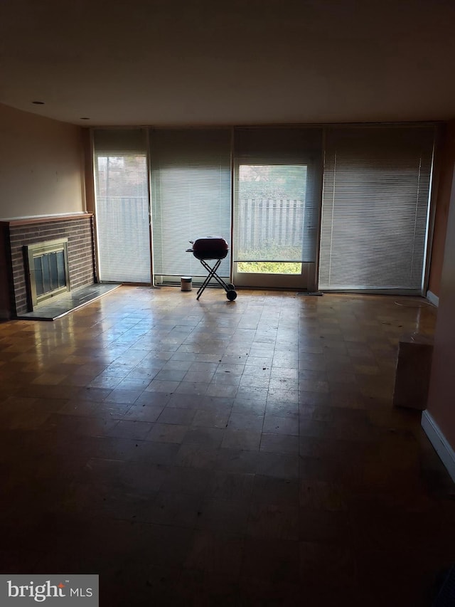 unfurnished living room with a fireplace and baseboards