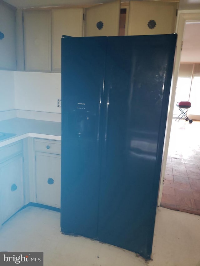 kitchen featuring freestanding refrigerator and light countertops