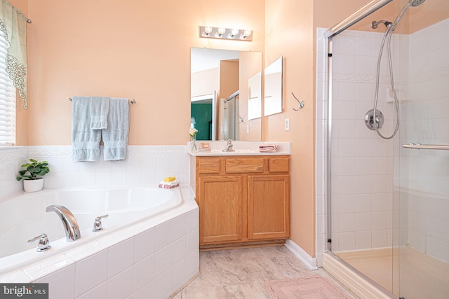 bathroom featuring vanity and independent shower and bath