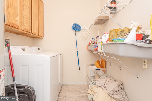 laundry area featuring washer and dryer and cabinets