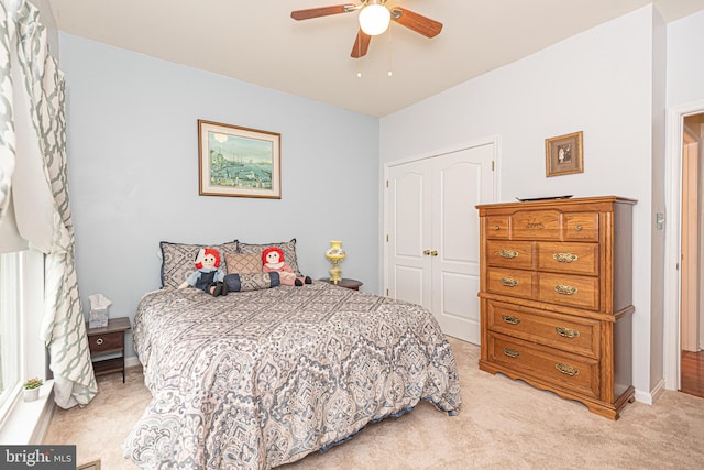 carpeted bedroom with ceiling fan and a closet