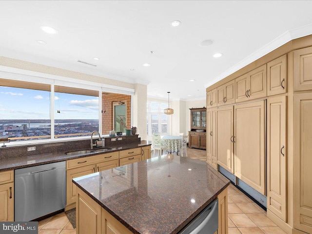 kitchen featuring sink, a center island, dark stone countertops, stainless steel dishwasher, and ornamental molding